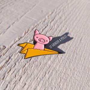 Pin’s Petit cochon sur avion en papier